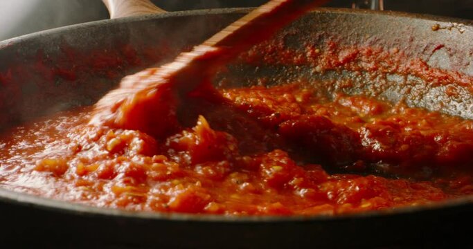 Italian tomato sauce is boiling and stirring in a pan for pizza or pasta, 4k footage