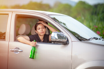 dangerous driving - young woman drinking beer and driving car,  drinking alcohol in vehicle and road accidents concept