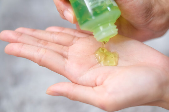 Woman Applying Aloe Vera Gel On Hand With Carpet Background, Health Care Concept.