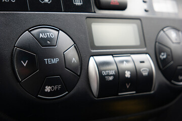 Generic car automatic climate control black plastic dials close up shot