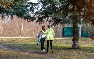 Fototapeta premium Two girlfriends walk along a path in the Park 