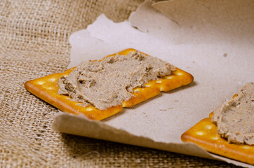 Rectangular liver pate crackers on a burlap sack.