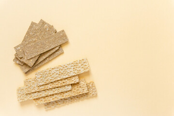 Healthy whole grain and waffle crispbread on beige background, space for text