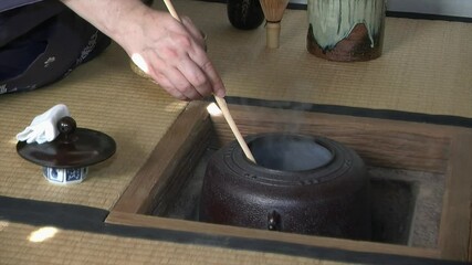 Ladle of hot water is poured into Japanese tea bowl during Japanese tea ceremony (chanoyu).