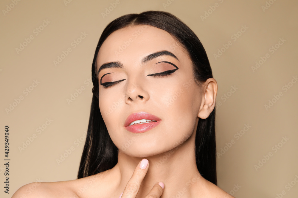 Sticker Beautiful woman with black eyeliner on beige background