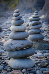 Fototapeta na wymiar Stone piles made along a beach and the sea in the background. High quality photo