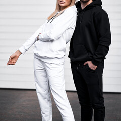 young bearded man and blonde girl is standing in plain hoodie for logo printing. Clothing mockup for hoodie. Autumn youngsters streetwear
