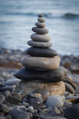 Fototapeta na wymiar Stone piles made along a beach and the sea in the background. High quality photo
