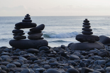 Stone piles made along a beach and the sea in the background. High quality photo