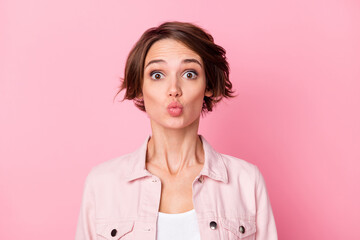 Photo portrait of woman sending air kiss isolated on pastel pink colored background