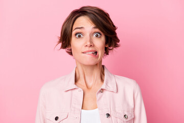 Photo portrait of scared girl biting lower lip isolated on pastel pink colored background
