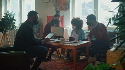 Team of Young Professionals Wearing Face Masks, Talking on a Meeting in Modern Creative Office. Diverse Team of Social Media Marketing Professionals Brainstorm, Share Data on Tablet Computer, Innovate - Powered by Adobe