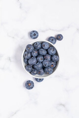 Blueberry into a white bowl. White background, selective focus