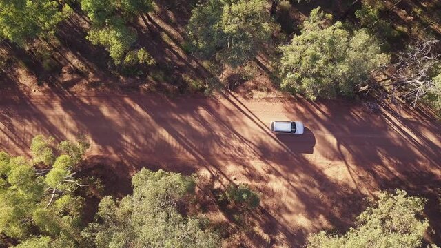 Top down view of a car passing and driving on the iconic Australian red dirt outback road.