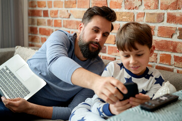 Father and son looking at smart phone