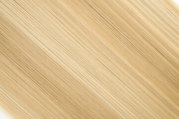 closeup of single piece of clip in straight brown mixed blonde highlights synthetic hair extensions