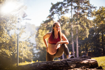 Pregnant woman has exercise in the nature.