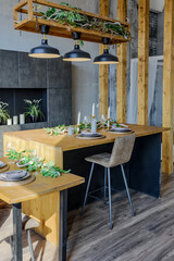 Dark loft style interior of big cozy country house. open plan apartment with kitchen area, rest zone and bed area. Huge windows and wooden decoration