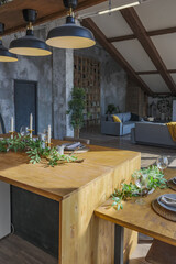 Dark loft style interior of big cozy country house. open plan apartment with kitchen area, rest zone and bed area. Huge windows and wooden decoration