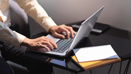 Businessman hands typing on laptop keyboard on portable workspace