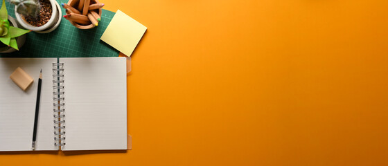 Creative flat lay study table with stationery, plant pots and copy space on yellow background