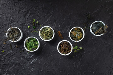 Sea vegetables assortment, overhead flat lay shot on a black background
