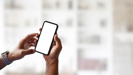 Close up view of man hands using mock up smartphone in blurred background