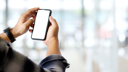 Close up view of a man hands using smartphone in blurred background