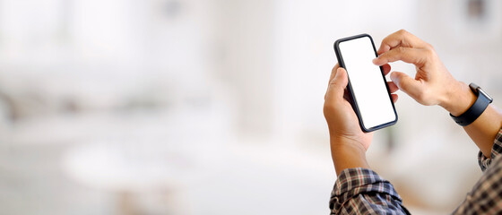 Cropped shot of a man hands using mock up smartphone in blurred background