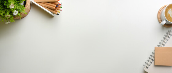 Creative flat lay workspace with stationery, coffee cup, plant pot and copy space