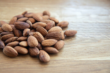 Crude almonds nuts on wooden background. Side view