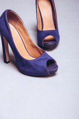 Womens violet worn shoes high heels on gray background. After party, fashion concept. Side view