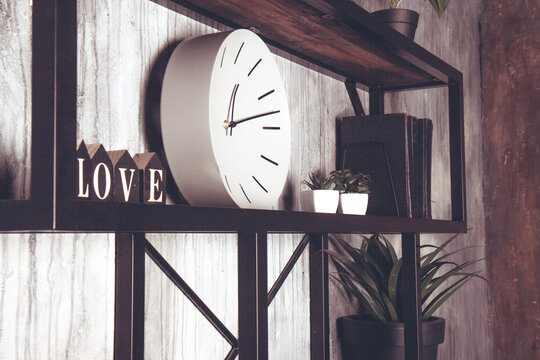 Shabby chic interior decor. White round clock and wooden letters on a vintage shelf. Word love made from wooden cubes. Home space decoration