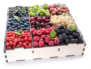 Colorful berries in wooden box on white background. Top view.