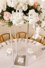 Festive Floral decor on wedding banquet tables in white colors with cutlery