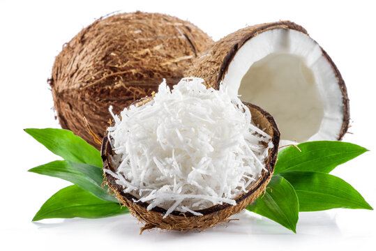Coconut fruit and shredded coconut flakes in the piece of shell isolated on white background.