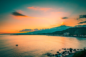 Silhouette of a mountain by the sea at sunset, teal and orange concept. Sunset on the coast of...