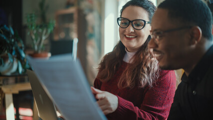 Team of Young Professionals Wearing Face Masks, Talking on a Meeting in Modern Creative Office. Diverse Team of Social Media Marketing Professionals Brainstorm, Share Data on Tablet Computer, Innovate