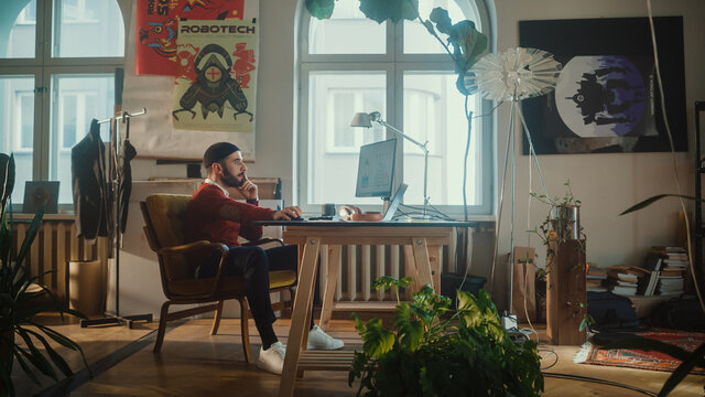 Creative Modern Office: Young Man Sitting at His Desk Working on Computer. Authentic Professional Creators, Developers, Creating Great Content. 