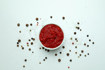 Bowl with tomato paste, pepper and salt on white background