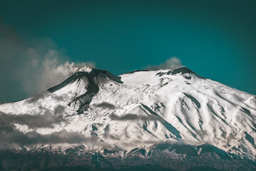  Smoking craters  of Mount Etna - the highest active volcano in Europe. Teal background 