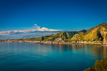 Beauty on the coast of Taormina, marvelous turquoise water and snowy mountains in the background 