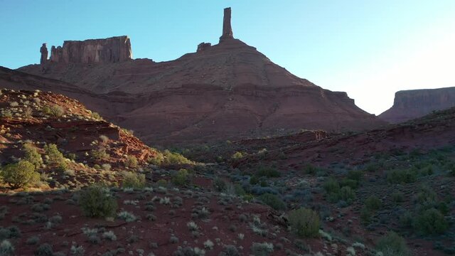 Aerial 4K video of Castleton Tower red rock formation in Utah. Drone shot flying forward while tilting up to reveal the 400ft rock spire.