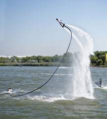  The athlete flies with a water jet from the side of a water motorcycle in front of the audience at...