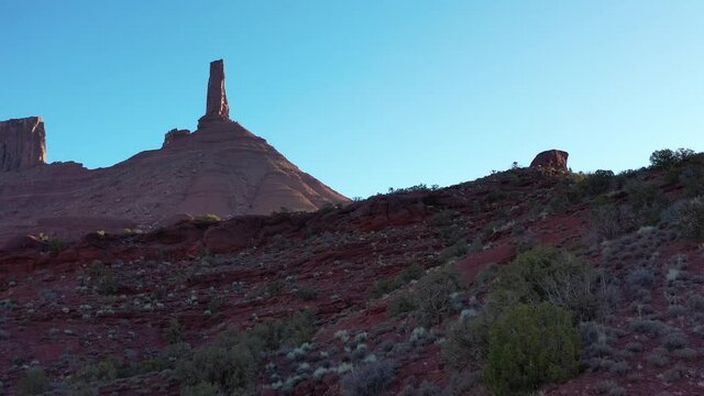 Drone video looking up at Castleton Rock in Utah while slowly flying forward over desert landscape