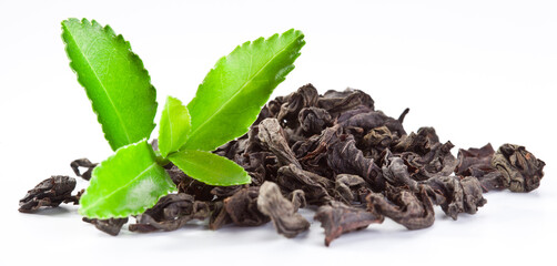 Dried tea leaves with fresh green tea leaves isolated on a white background.