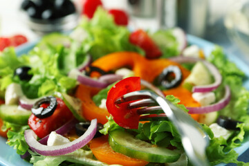 Delicious greek salad and fork, close up