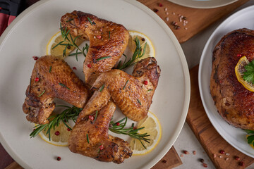 Roasted chicken wings in barbecue sauce and mixed vegetable salad with pepper seeds rosemary, salt in white plate on light color stone table. top view with copy space. tasty snack. Flat lay.