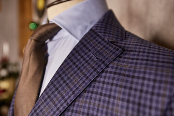 Men's casual checkered tweed coat and blue shirt collar with tie closeup