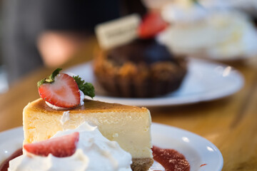 Slice of cheesecake with whipped cream and strawberry. Selective focus